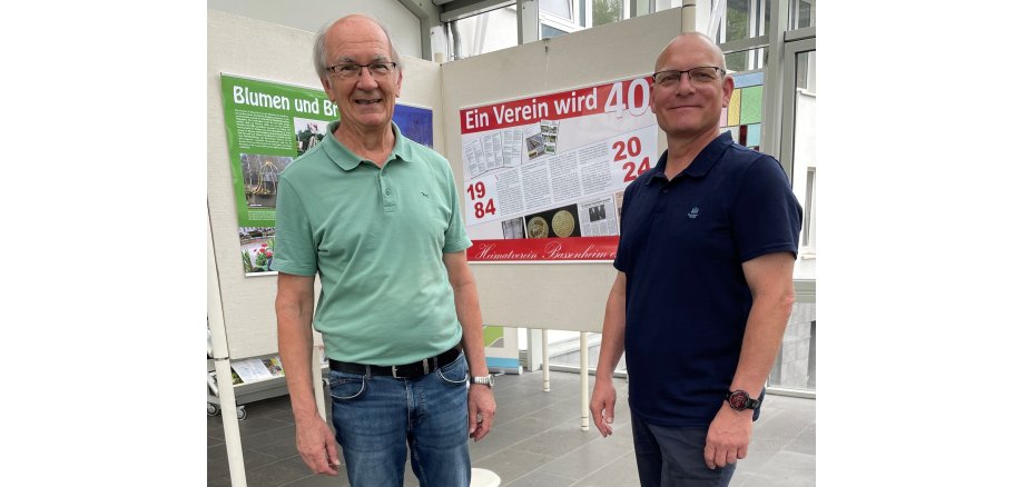 Vor zwei im rechten Winkel angeordneten Stellwänden stehen links der 2. Vorsitzende des Heimatvereins Bassenheim, Horst Walter und das Vorstandsmitglied Karsten Schwarz.