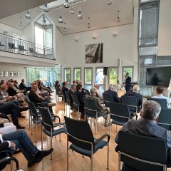 Blick in das Auditorium mit voll besetzten Stuhlreihen.