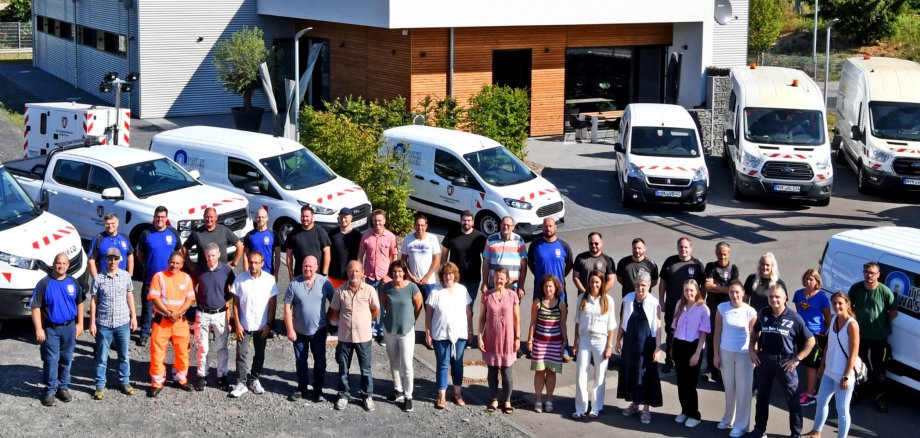 Alle Mitarbeiterinnen und Mitarbeiter der Verbandsgemeindewerke stehen vor dem neuen Betriebsgebäude in einem Halbkreis. 