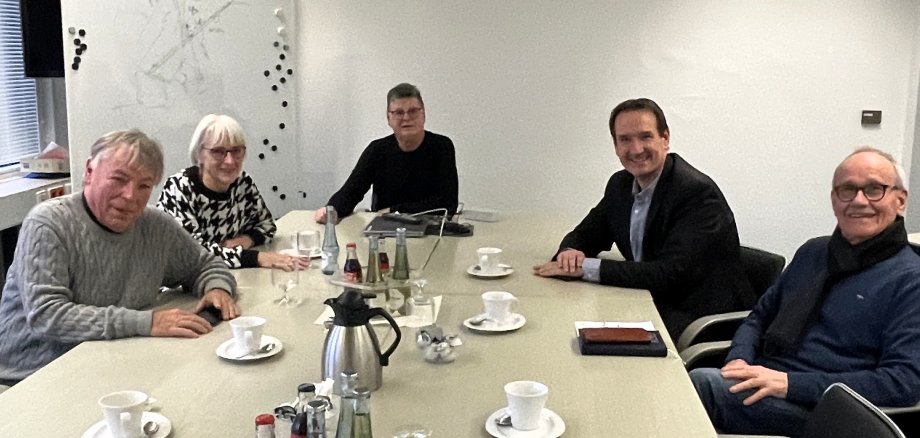 An einem Tisch mit Getränken darauf sitzen rechts der Vorsitzende des Seniorenbeirats, Hajo Reif, Bürgermeister Thomas Przybylla und gegenüber Tafel-Vorsitzender Peter Bäsch, Annette Bäsch und der 2. Vorsitzende Alfred Waurig.